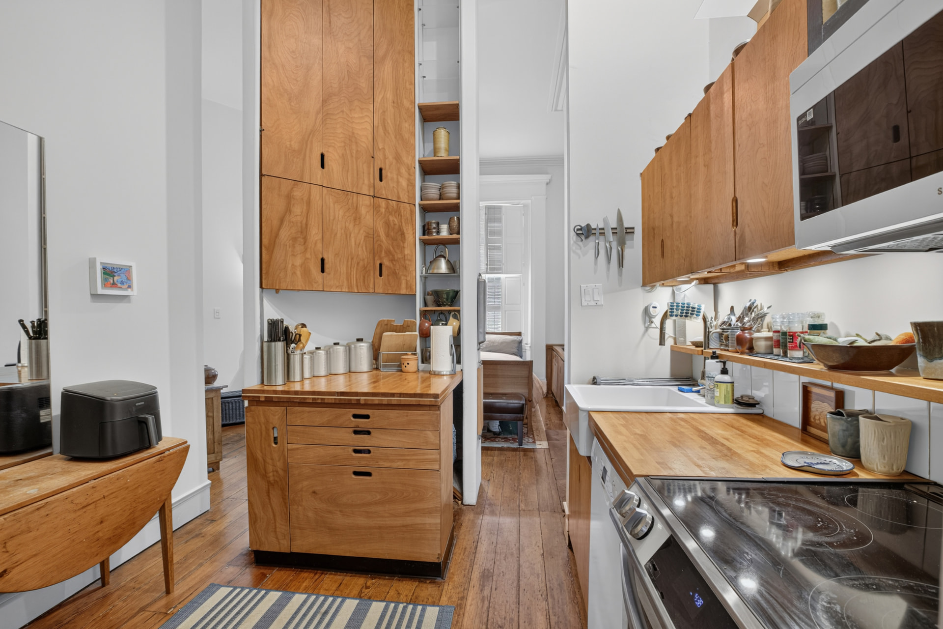 Kitchen with custom cherry cabinetry, butcher block counters and plank floors